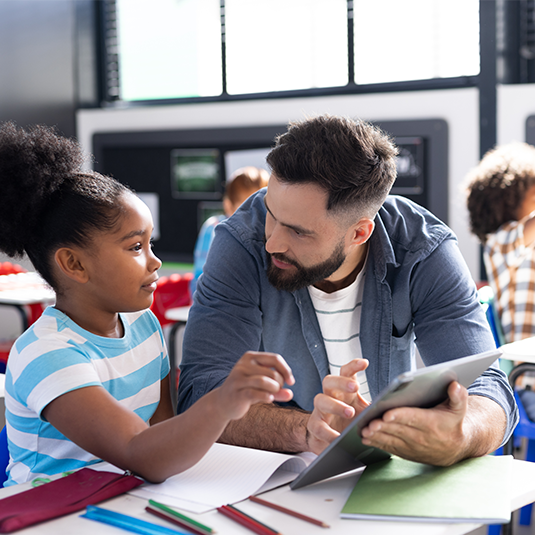 Adulte semblant guider une jeune élève dans son apprentissage.